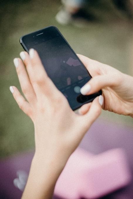 A persons hands on a phone.