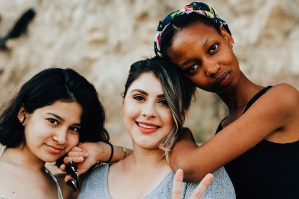 Group of females stood together smiling.