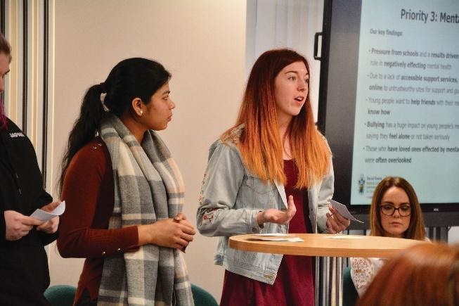 Two girls presenting to an audience.