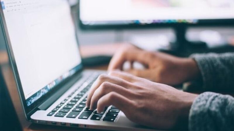 Hands typing on a laptop.
