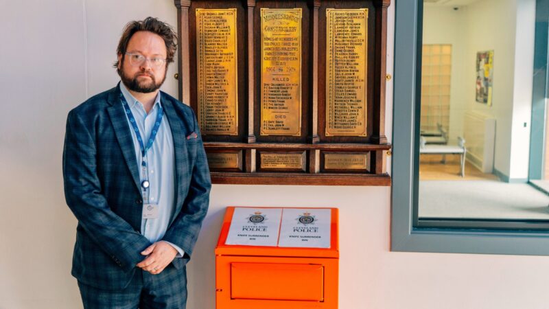 PCC Matt Storey stood next to an orange knife surrender bin.