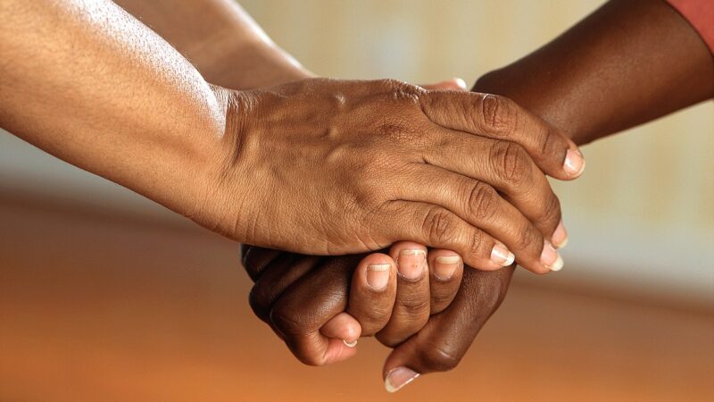 Two hands clasping one another in support