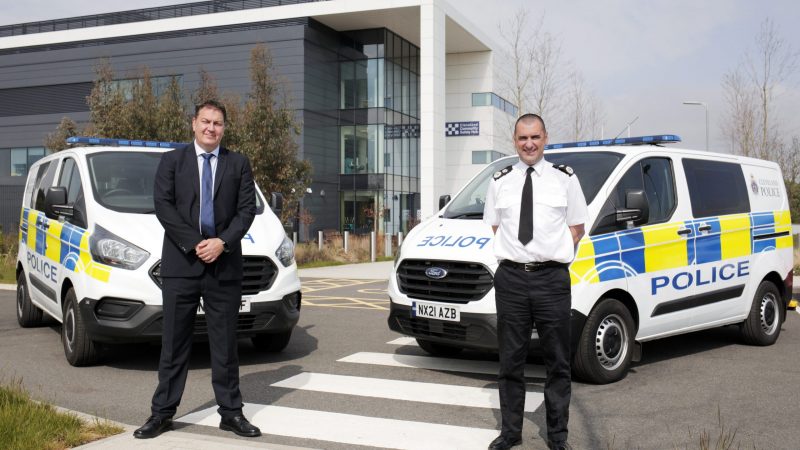 PCC Steve Turner and Chief Constable Richard Lewis stood in front of two police vans